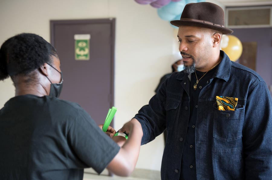 A student volunteer puts a wristband on an attendee. Open Gallery